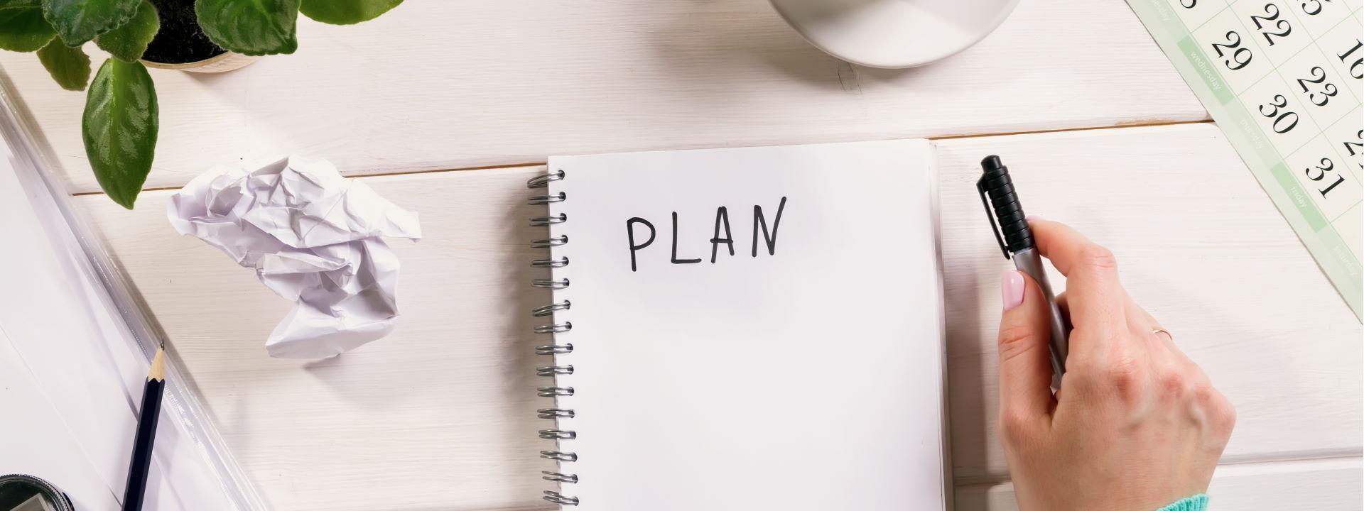 Calendar and open notebook with plan showing