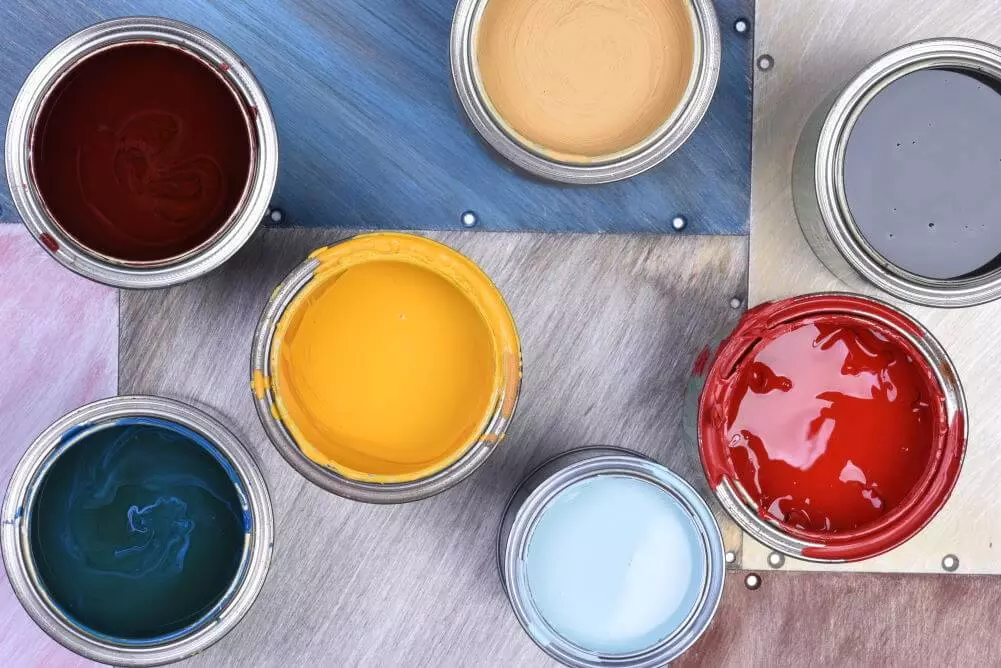 Paint cans with 2022 colors blue, yellow, aubergine, red