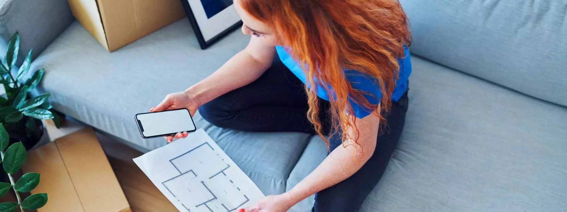 Red haired lady looking at floor plan 